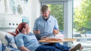 two Forth Valley College nursing students participate in a practice blood pressure test