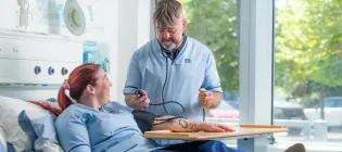 two Forth Valley College nursing students participate in a practice blood pressure test