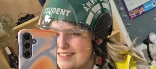 Nicole, wearing her student paramedic uniform, takes a mirror selfie