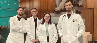 4 students pose in white coats with stethoscopes