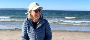 Lesley smiling on beach