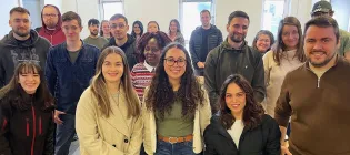 about 20 adult students smile at the camera