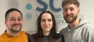three students smile at the camera