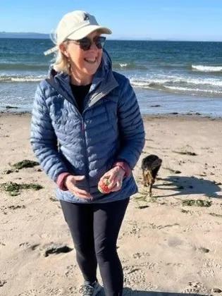 Lesley Dunbar is with her dog on a beach