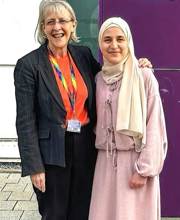 Lesley Dunbar and Batoul pose outside a medical building, smiling and with their arms around each other